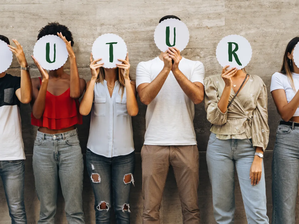 Junge Menschen halten Schilder, die den Schriftzug Future bilden, hoch. 